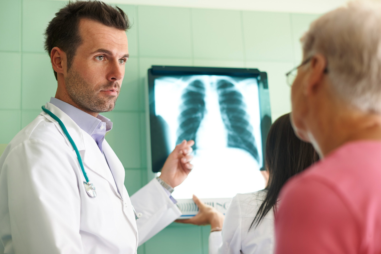 Profissional de enfermagem mostrando uma radiografia a um paciente