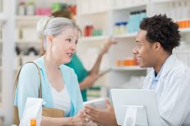 Farmacêutico explicando o uso de medicamentos para paciente.