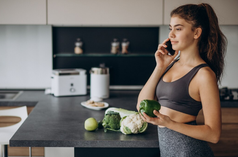 Mulher fitness com legumes frescos, reforçando educação alimentar