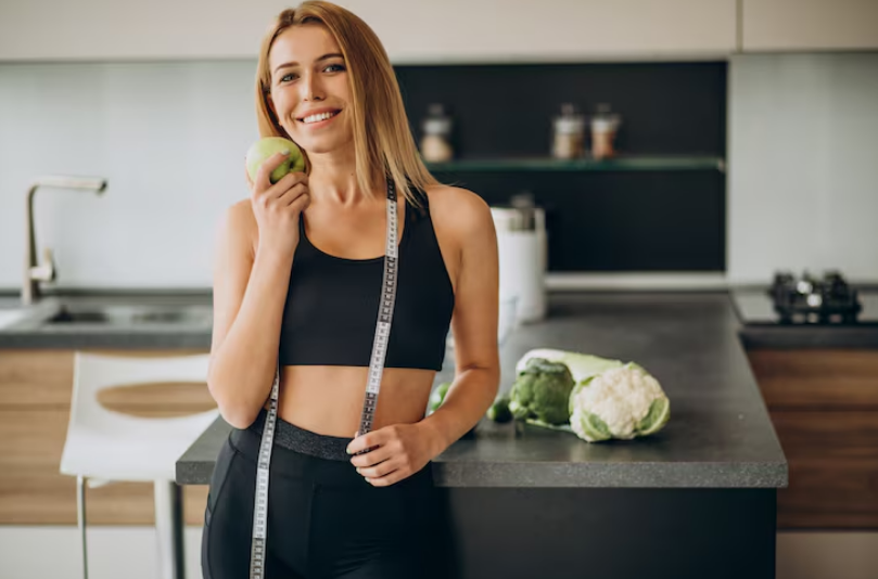 Mulher fitness segurando maçã, representando escolhas alimentares conscientes