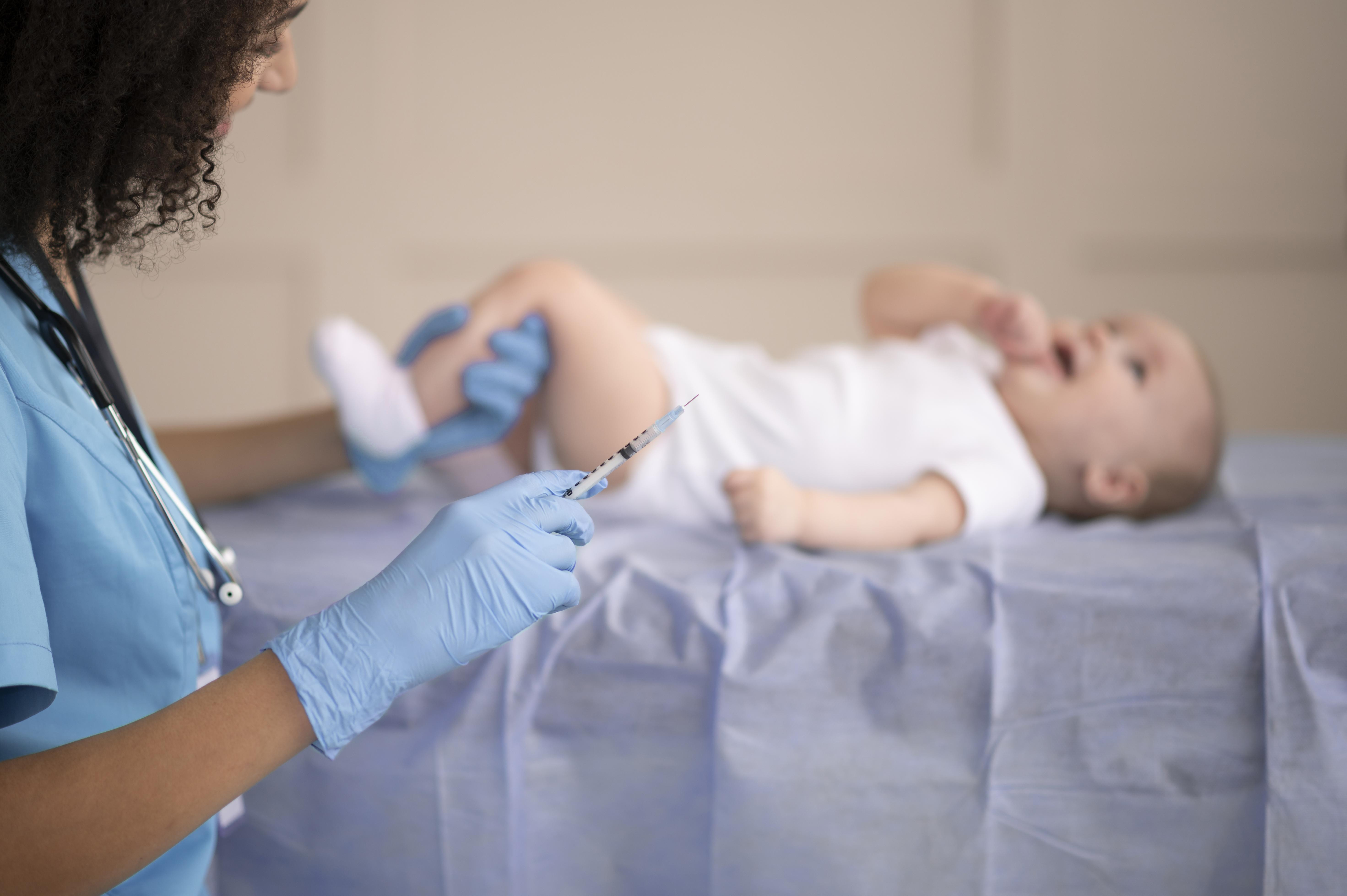 Profissional de saúde aplicando vacina em bebê