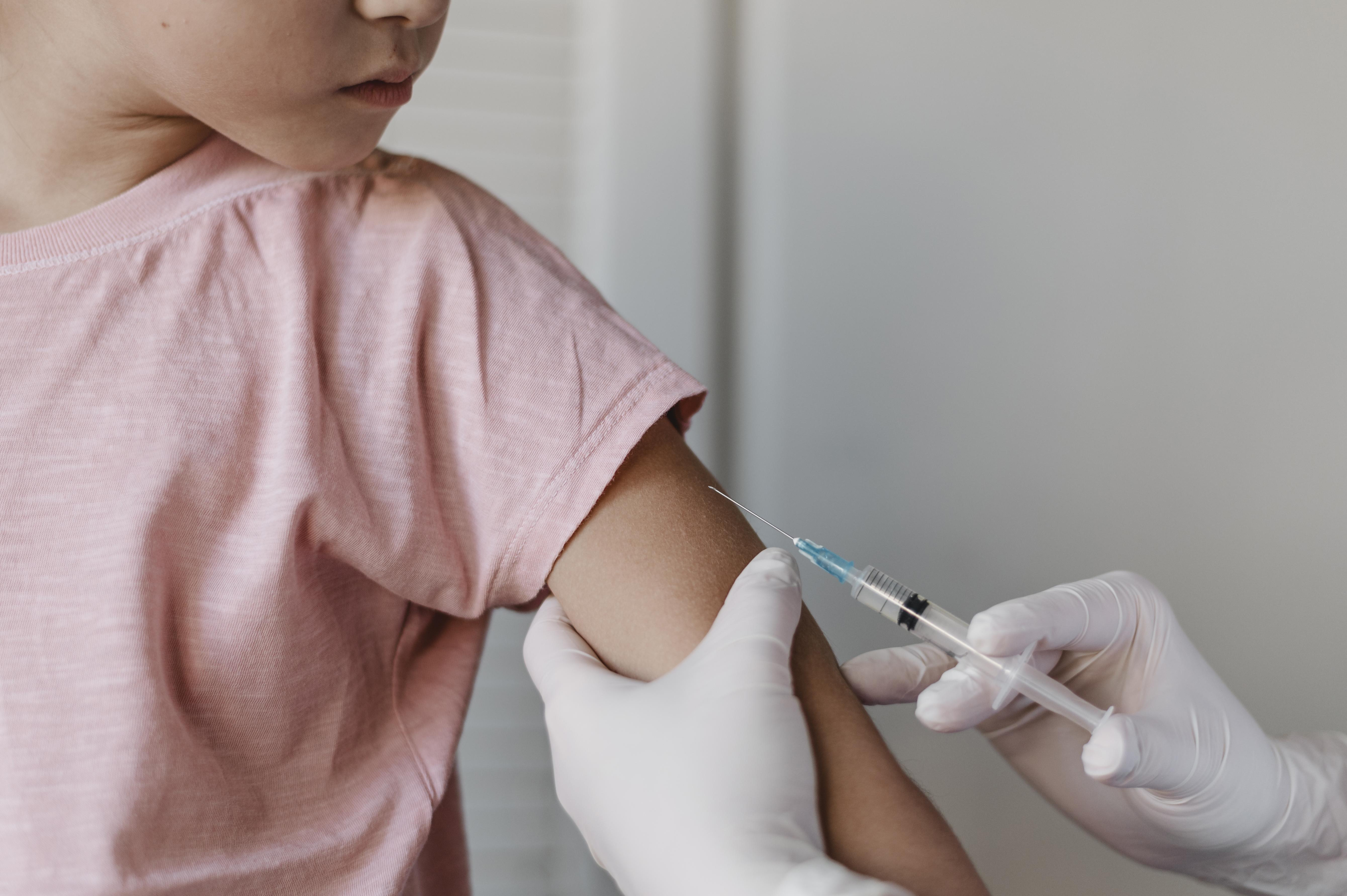 Criança recebendo vacinação no braço com profissional de saúde