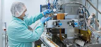 Equipamentos de alta tecnologia utilizados na produção de medicamentos, com sistema computadorizado e ambiente controlado.