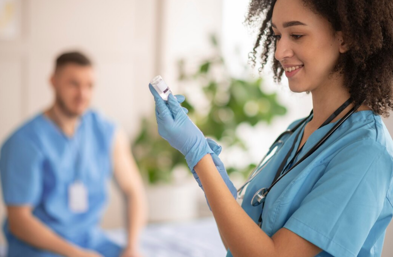 Profissional de enfermagem conferindo medicação em ambiente clínico