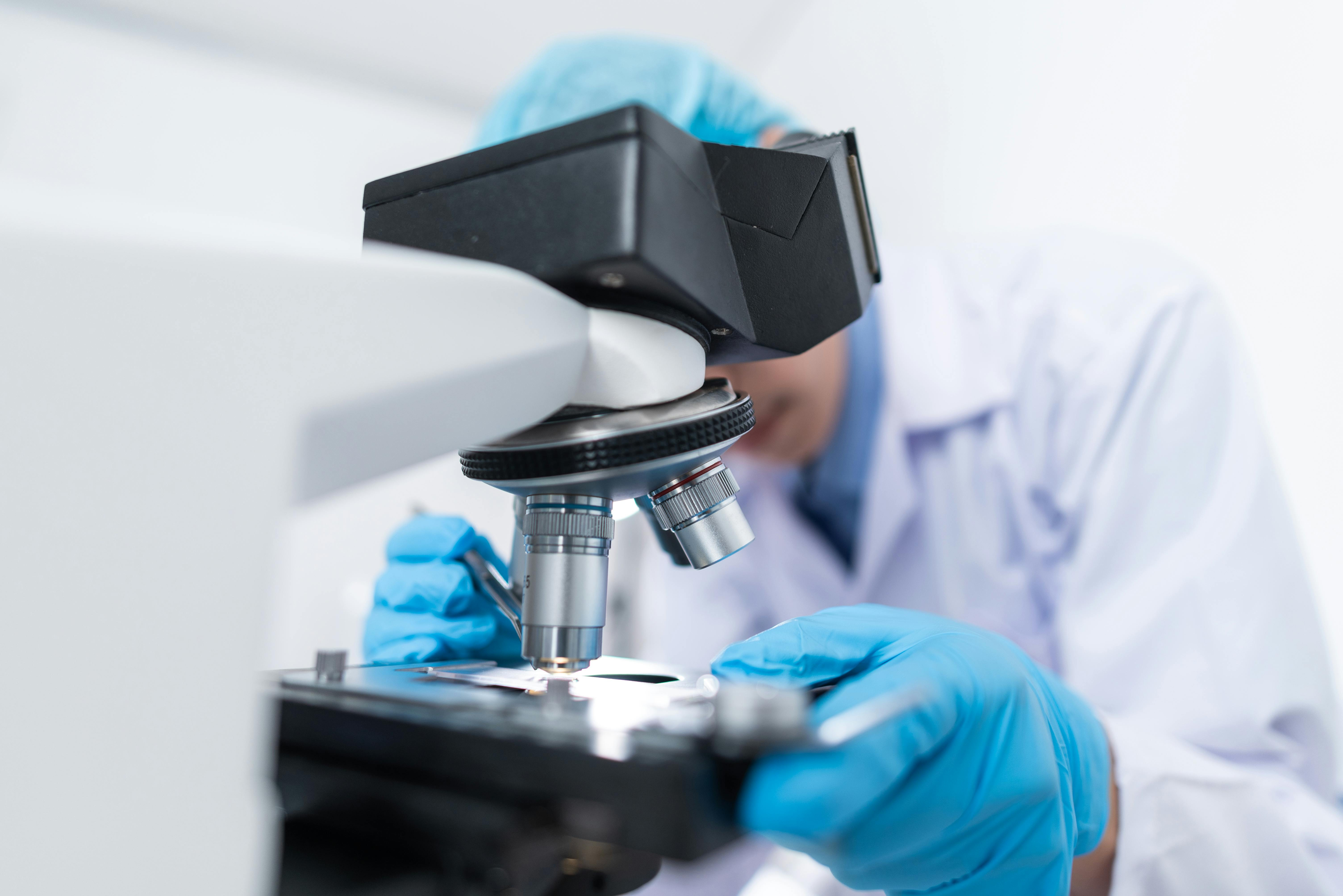 Pesquisador em laboratório analisando amostras no microscópio, representando avanços e inovações na biotecnologia