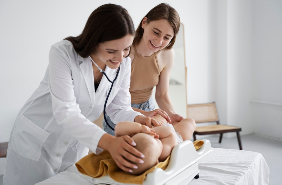 Médica avalia recém-nascido em balança ao lado da mãe